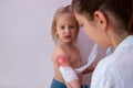 Pediatrician is dressing wound on toddler arm with a sterile non-adhesive bandage