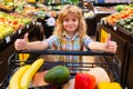 Child buying fruit in supermarket. Kid buy fresh vegetable in grocery store. Kids in shop, healthy food. Boy having fun Royalty Free Stock Photo