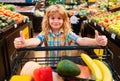 Child buying fruit in supermarket. Kid buy fresh vegetable in grocery store. Kids in shop, healthy food. Boy having fun Royalty Free Stock Photo