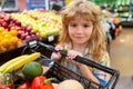 Child buying fruit in supermarket. Kid buy fresh vegetable in grocery store. Kids in shop, healthy food. Healthy kids Royalty Free Stock Photo