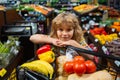 Child buying fruit in supermarket. Kid buy fresh vegetable in grocery store. Kids in shop, healthy food. Shopping cart Royalty Free Stock Photo