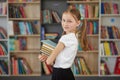 Child buys books in bookstore for learning or reading. Girl choosing book in school library Royalty Free Stock Photo