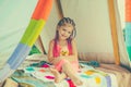 Child camping concept. Happy kid with dreadlocks play in tent. Girl playing in camp. Having fun outdoors at campground.