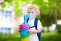 Child with candy cone in school in face mask Royalty Free Stock Photo