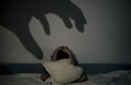 child cannot sleep because of the fear of the dark, the frightened boy hides under the pillow. insomnia, childish fear.