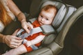 Child in car mother putting baby in safety car seat Royalty Free Stock Photo