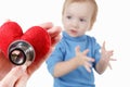 Child and cardiologist, heart symbol in hand, stethoscope.