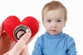 Child and cardiologist, heart symbol in hand, stethoscope.