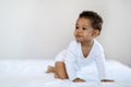 Child Care. Black Baby Boy Or Girl Crawling On Bed At Home Royalty Free Stock Photo