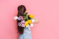 A child carries a bouquet of tulips on his shoulder against a pink background Royalty Free Stock Photo