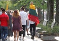 A child carries a fluttering tricolor Lithuanian flag outdoors. Kaunas Lithuania
