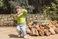 Child carying big rock in garden