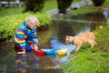 Child with paper boat in puddle. Kids by rain Royalty Free Stock Photo