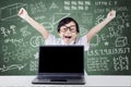 Child celebrate her success with laptop in class Royalty Free Stock Photo