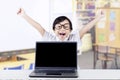 Child celebrating her winning with laptop in class Royalty Free Stock Photo