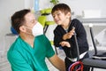 Child with cerebral palsy on physiotherapy in a children therapy center. Boy with disability doing exercises with