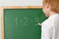 The child with a chalk near a board Royalty Free Stock Photo