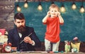 Child cheerful and teacher painting, drawing. Talented artist spend time with son. Teacher with beard, father teaches Royalty Free Stock Photo