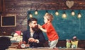 Child cheerful and teacher painting, drawing. Teacher with beard, father teaches little son to draw in classroom Royalty Free Stock Photo