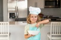 Child chef cook with cooking plate. Chef kid boy baking on the kitchen. Child chef cook prepares food at kitchen. Kids Royalty Free Stock Photo