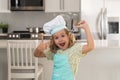 Child chef cook prepares food at kitchen. Kids cooking. Teen boy with apron and chef hat preparing a healthy meal. Royalty Free Stock Photo