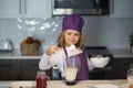 Child chef cooking meal. Child chef cook is learning how to make a cake in the home kitchen. Royalty Free Stock Photo