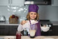 Child chef cooking meal. Child making tasty delicious. little boy in chef hat and an apron cooking in the kitchen. Royalty Free Stock Photo