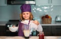 Child chef cooking meal. Child making tasty delicious. little boy in chef hat and an apron cooking in the kitchen. Royalty Free Stock Photo