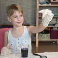 A child chemist admires the results of a scientific experiment. A child biologist studies small microorganisms. The girl