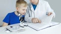 Child chemist. Teacher shows a visual experiment. A science mentor teaches an experimental approach. Microscope, petri dish, Royalty Free Stock Photo