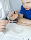 Child chemist. Teacher shows a visual experiment. A science mentor teaches an experimental approach. Microscope, petri dish, Royalty Free Stock Photo