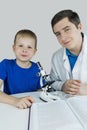 Child chemist. Teacher shows a visual experiment. A science mentor teaches an experimental approach. Microscope, petri dish, Royalty Free Stock Photo