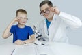 Child chemist. Teacher shows a visual experiment. A science mentor teaches an experimental approach. Microscope, petri dish, Royalty Free Stock Photo