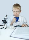 Child chemist. Teacher shows a visual experiment. A science mentor teaches an experimental approach. Microscope, petri dish, Royalty Free Stock Photo