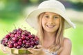 Child with cherries. Little girl with fresh cherries. Portrait of a smiling young girl with bowl full of fresh cherries