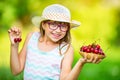 Child with cherries. Little girl with fresh cherries. Young cute caucasian blond girl wearing teeth braces and glasses. Royalty Free Stock Photo