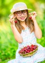 Child with cherries. Little girl with fresh cherries. Young cute caucasian blond girl wearing teeth braces and glasses. Royalty Free Stock Photo