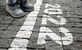 A child in children`s shoes on paving stones in front of the starting line and the text 2022. Concept of the New Year Royalty Free Stock Photo