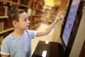 Child choosing book using touchscreen Royalty Free Stock Photo