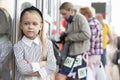 A child in the city in front of people. A little girl on the street.