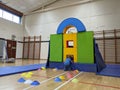 Child climbing into a base fort made of mats and pads