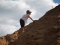 Child is climbing a mountain of sand. Royalty Free Stock Photo