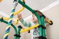 Child climbing to banana on gymnastic bar.Children workout. Child health care and physical training concept. Happy and healthy Royalty Free Stock Photo