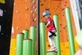 Child climbing on wall in amusement centre. Climbing training for children. Little girl in dressed climbing gear climb high. Royalty Free Stock Photo