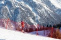 The child climbs up the travolator on the ski slope behind a red protective mesh. Royalty Free Stock Photo