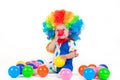 Child clown with a red nose multicolored wig in with balls Royalty Free Stock Photo