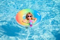 Child with cocktail on watter pool in the summer. Cute funny little toddler boy in sunglasses relaxing with toy ring
