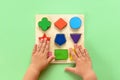 The child collects a multicolored wooden sorter. Educational logic toy for kid& x27;s