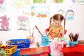 Child with colour pencil in play room.