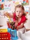 Child with colour pencil in preschool.